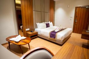 a hotel room with a bed and a table at Ramnaa Hotel in Jāmb