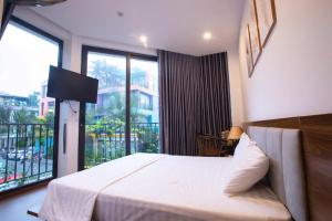 a bedroom with a bed and a large window at Villa Flamingo C607 in Thanh Hóa