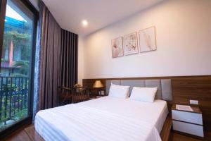 a bedroom with a white bed and a large window at Villa Flamingo C607 in Thanh Hóa