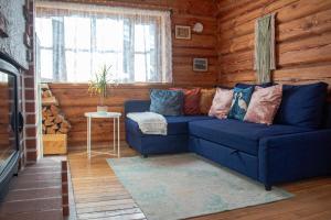 ein Wohnzimmer mit einer blauen Couch in einer Blockhütte in der Unterkunft Zemene in Bauska