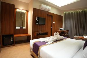 a hotel room with a bed with towels on it at Ramnaa Hotel in Jāmb
