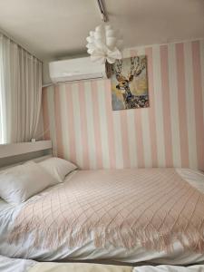 a bedroom with a bed with a striped wall at binna stay 이태원역7분, 독채,테라스,4 Queen Beds, 무료짐보관 , 명동,홍대,서울역,명동 15분 in Seoul