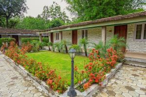 a garden with red flowers and a street light at Bardibas Resort in Tulsi