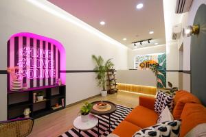 a living room with an orange couch and a pink window at Olive Hotel JP Nagar Metro by Embassy Group in Bangalore