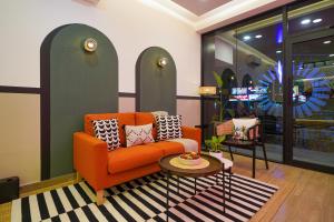 a living room with an orange couch and a table at Olive Hotel JP Nagar Metro by Embassy Group in Bangalore
