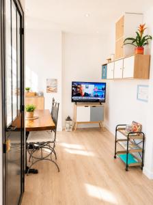 a living room with a table and a tv at LES COQUILLAGES, plage et centre à pied, lits faits, 2 sdb in Berck-sur-Mer