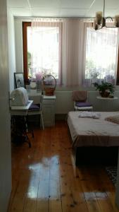 a room with two beds and a table and windows at Hank O'brat in Lovech