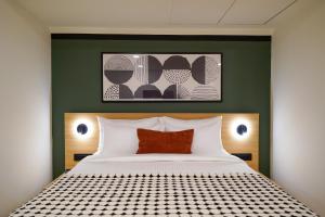 a bedroom with a bed and a green wall at Olive Hotel JP Nagar Metro by Embassy Group in Bangalore +29 photos