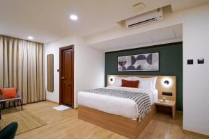 a hotel room with a bed and a chair at Olive Hotel JP Nagar Metro by Embassy Group in Bangalore