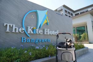 a dog sitting in a cart in front of a sign at The Kite Hotel Bangsaen by Koko in Ban Laem Thaen