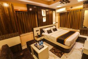 a hotel room with a bed and a couch at Mohar Residency - VIP Road in kolkata
