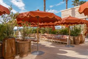 an outdoor patio with tables and chairs and umbrellas at Hôtel Villa M Marseille in Marseille