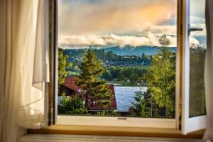 ein Fenster mit Blick auf einen See und ein Haus in der Unterkunft Element Residence in Lipno nad Vltavou