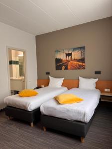 two beds in a hotel room with at Hobbit Hotel Brussels Airport Zaventem in Zaventem