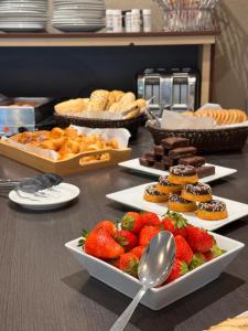 a table with plates of food and strawberries and pastries at Hobbit Hotel Brussels Airport Zaventem in Zaventem +11 photos