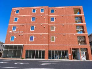 a red brick building with windows on a street at レガリアイン in Okayama