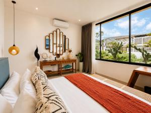 a bedroom with a bed and a large window at Village Berawa in Badung +59 photos