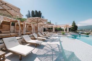 a row of lounge chairs next to a swimming pool at Azanti Residence in Ulcinj