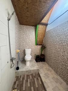 a bathroom with a toilet in a room at Rising Sun Bungalows in Gili Meno +73 photos