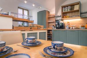 a kitchen with a wooden table and blue cabinets at Garni Hotel Zum Hothertor in Görlitz