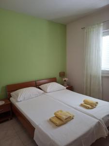a bedroom with a large white bed with towels on it at Apartments Maskovic Karbuni in Prizba