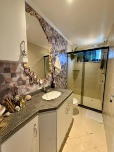 a bathroom with a sink and a mirror at Apartamento Praia da Costa in Vila Velha