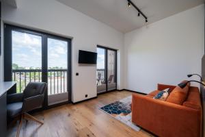 a living room with a couch and a balcony at New apartment in Karlova in Tartu