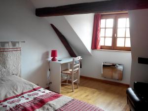 a bedroom with a bed and a desk with a red lamp at Gite duplex du vignoble Alsace in Rouffach