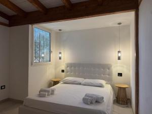 a bedroom with a white bed with two towels on it at A casa di Raf in Torre Lapillo