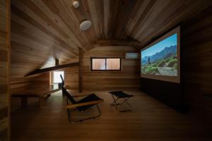 a room with a flat screen tv in a wooden ceiling at ひのまきbase-暖- in Uda