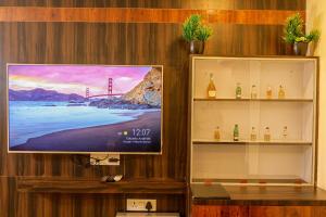 a flat screen tv on a wall with a display shelf at Bardibas Resort in Tulsi
