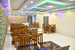 a restaurant with wooden chairs and tables and purple lights at S S Plaza in mayapur