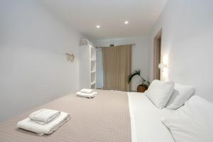 a white bedroom with white towels on a bed at Crystal Dream Paros in Kampos Paros +194 photos