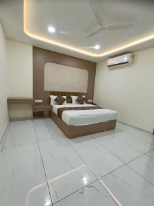 a bedroom with a large bed and white tile floors at Hotel Radhe Raas in Vāsad