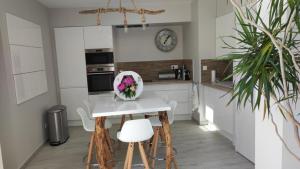 a kitchen with a table and chairs and a clock at LA MAISON DE MARIE A 8 mn des plages in Perpignan