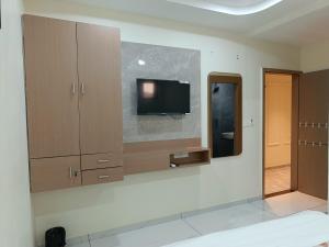 a bathroom with a tv on a wall at Hotel Radhe Raas in Vāsad