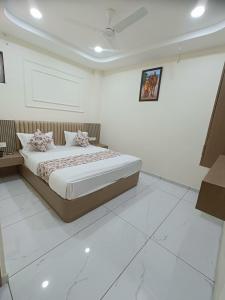 a bedroom with a bed in a white room at Hotel Radhe Raas in Vāsad