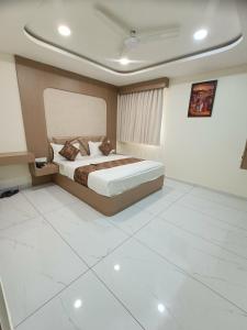 a bedroom with a large bed in a room at Hotel Radhe Raas in Vāsad +8 photos
