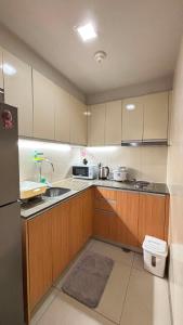 a small kitchen with a sink and a refrigerator at The Mactan Newtown in Punta Engaño