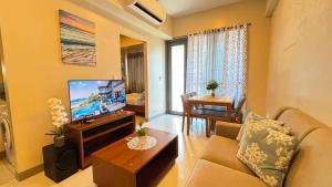 a living room with a couch and a television at The Mactan Newtown in Punta Engaño