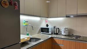 a small kitchen with a sink and a microwave at The Mactan Newtown in Punta Engaño +3 photos