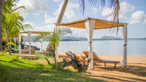 a gazebo and chairs on the beach at Ampasoa Beach in Nosy Be