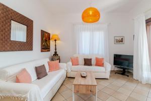 a living room with two white couches and a table at Villa Oleandro - 2349447 in San Teodoro