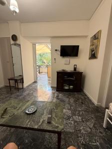 a living room with a table and a tv at Boutique Sea & Garden in Vari