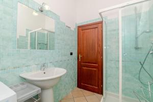 a bathroom with a sink and a shower with a mirror at Villa Oleandro - 2349447 in San Teodoro +17 photos