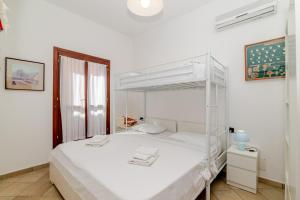 a white bedroom with a white bunk bed at Villa Oleandro - 2349447 in San Teodoro