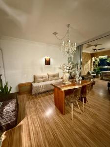 a living room with a chandelier and a table at Apartamento Praia da Costa in Vila Velha