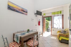 a living room with a table and chairs and a couch at San Teodoro Monti22 vicino spiaggia in San Teodoro