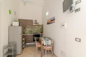a kitchen with a refrigerator and a table and chairs at San Teodoro Monti22 vicino spiaggia in San Teodoro +12 photos