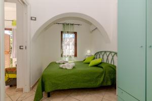 a bedroom with a green bed with a window at San Teodoro Monti22 vicino spiaggia in San Teodoro